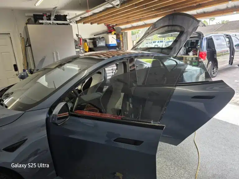 Vehicle prepared for window tinting in Kendall inside a garage