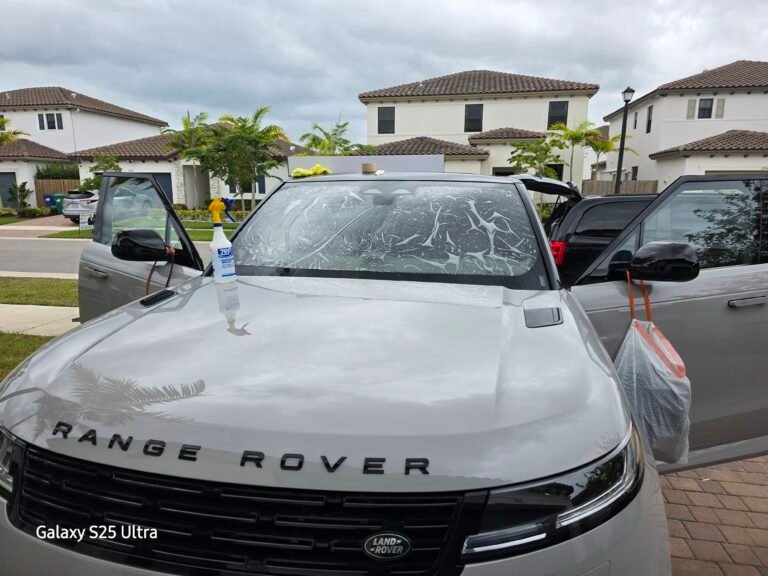 Servicios de polarizado de autos en Miami Instalación de película en el parabrisas delantero de un Range Rover blanco, con protectores en las puertas.