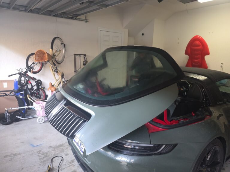 Servicios de polarizado de autos en Miami Cristal trasero elevado de un Porsche Targa durante un trabajo en un garaje.