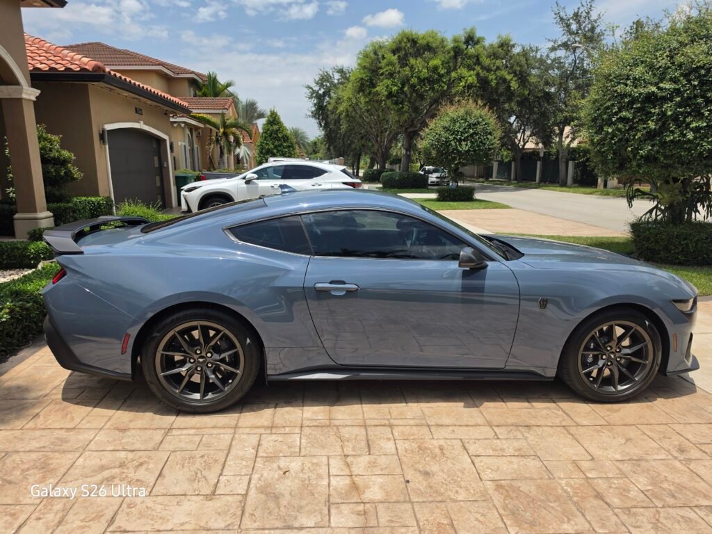 Mustang gris durante un trabajo de polarizado de autos en Hialeah, visto de lado con cristales polarizados