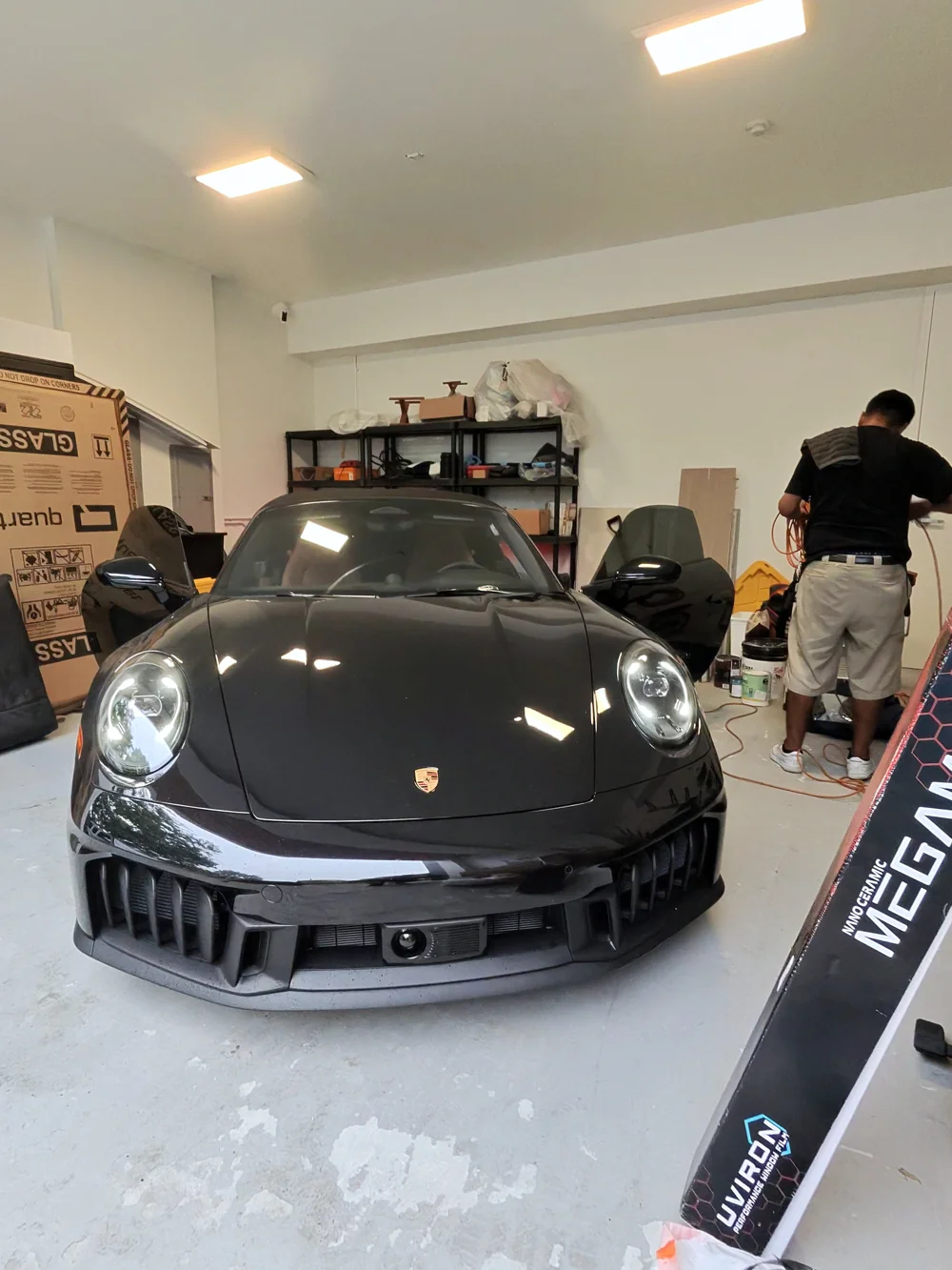 Black Porsche during window tinting in Coral Gables with installation materials visible